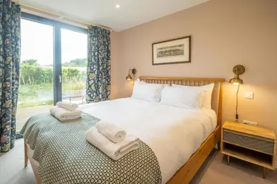 a bedroom with a bed with towels on it at Sedge House, Eastbridge, Close to the coast, RSPB Nature Reserve, Dunwich, Sizewell and Leiston - Managed by Aldeburgh Coastal Cottages in Theberton