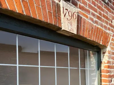 a window on a brick building with the number at Carleys Yard by The Suffolk Cottage Collection in Framlingham