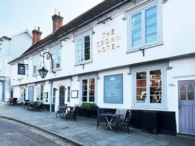 a white building with tables and chairs on a street at Carleys Yard by The Suffolk Cottage Collection in Framlingham
