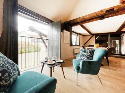 a living room with a couch and a chair at Carleys Yard by The Suffolk Cottage Collection in Framlingham