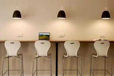 a bar with four white chairs and a computer at For Students Only - The Maltings in Colchester in Colchester