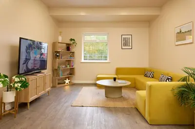 a living room with a yellow couch and a tv at For Students Only - The Maltings in Colchester in Colchester