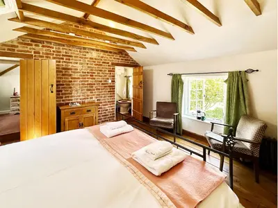 a bedroom with a large bed with two towels at Brick Kiln Holdings by The Suffolk Cottage Collection in Badingham