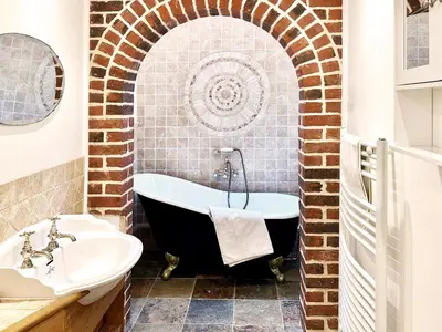 a bathroom with a bath tub and a sink at Brick Kiln Holdings by The Suffolk Cottage Collection in Badingham