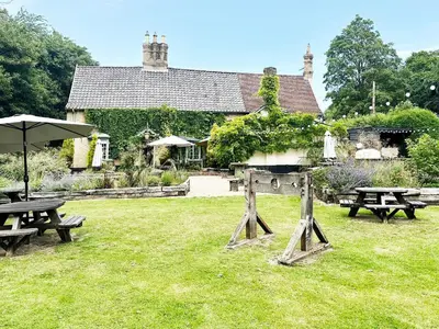 a group of picnic tables in front of a building at Brick Kiln Holdings by The Suffolk Cottage Collection in Badingham
