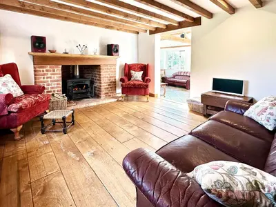 a living room with a couch and a fireplace at Brick Kiln Holdings by The Suffolk Cottage Collection in Badingham