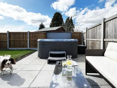 a dog standing on a patio with a table at Blackberry Barn by The Suffolk Cottage Collection in Long Melford