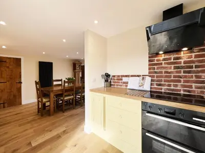 a kitchen and dining room with a brick wall at Blackberry Barn by The Suffolk Cottage Collection in Long Melford