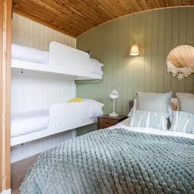 a bedroom with two bunk beds and a bed at Luxury Shepherd Hut with Private Hot Tub in Swaffham Bulbeck