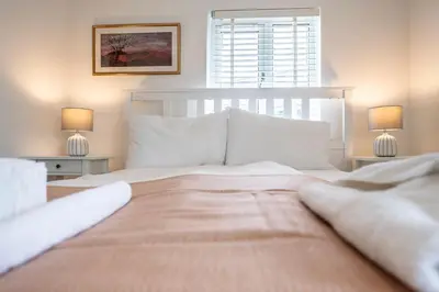 a bedroom with a large bed with two lamps at 19BC, Aldeburgh in Aldeburgh