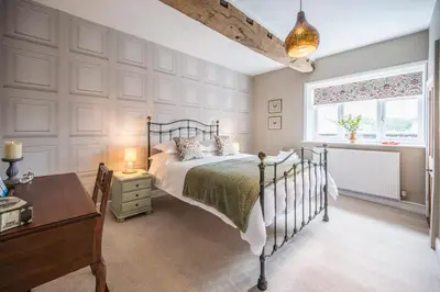 a bedroom with a bed and a desk and a window at Market View, Framlingham in Framlingham