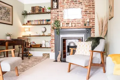 a living room with a brick fireplace and chairs at Market View, Framlingham in Framlingham