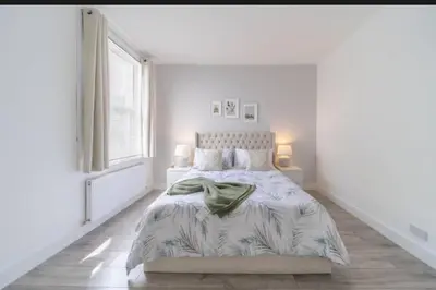 a white bedroom with a bed and a window at Stylish 3 Bed Seaside Apartment Central Southend Location & Steps from the Beach in Southend-on-Sea