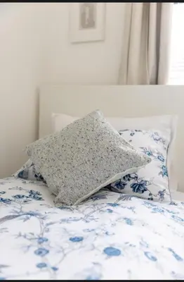 a pillow sitting on top of a bed at Stylish 3 Bed Seaside Apartment Central Southend Location & Steps from the Beach in Southend-on-Sea