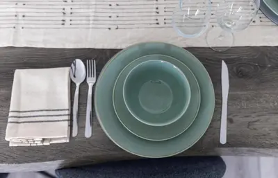 a table with a green plate and fork and knife at Stylish 3 Bed Seaside Apartment Central Southend Location & Steps from the Beach in Southend-on-Sea
