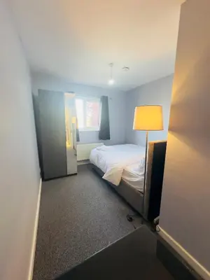 a small bedroom with a bed and a lamp at Cosy and Bright Stay Ipswich in Ipswich