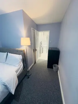 a bedroom with a bed and a lamp and a door at Cosy and Bright Stay Ipswich in Ipswich