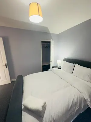 a bedroom with a large white bed and a couch at Cosy and Bright Stay Ipswich in Ipswich