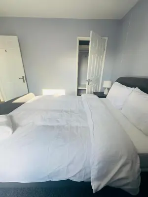 a large white bed with white sheets and pillows at Cosy and Bright Stay Ipswich in Ipswich