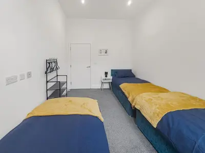 a room with two beds and a desk in it at Stylish 1B Apt in Essex w Modern Touch in Chelmsford