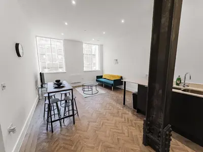 a kitchen and a living room with a table and chairs at Stylish 1B Apt in Essex w Modern Touch in Chelmsford