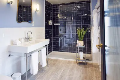 a bathroom with a sink and a shower with black tiles at The White Hart Inn in West Mersea