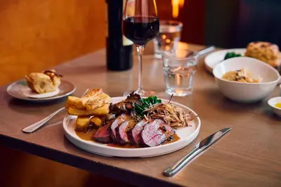 a table with a plate of food and a glass of wine at The White Hart Inn in West Mersea