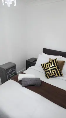 a bedroom with two beds with white sheets and pillows at Luxurious ensuite rooms in Basildon