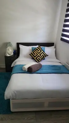 a bed with white sheets and pillows in a room at Luxurious ensuite rooms in Basildon