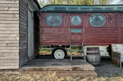 a red trailer sitting on the side of a house at Romantic 1920s Circus Wagon Experience in Sutton