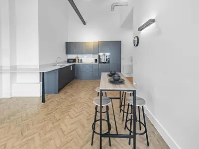 a kitchen with a table and stools in a room at Bright & Cozy in Chelmsford in Chelmsford