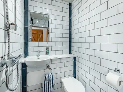 a white bathroom with a sink and a toilet at The Pink Cottage
