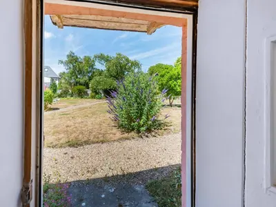 an open door with a view of a yard at The Pink Cottage