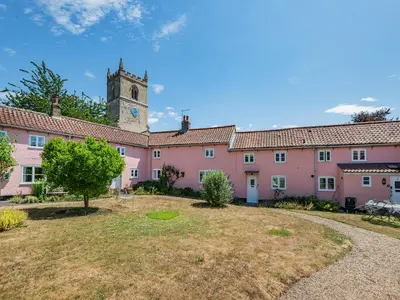 a large pink building with a clock tower at The Pink Cottage