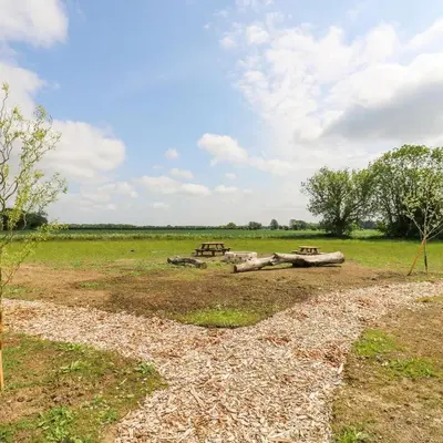 a group of picnic tables in a field at Luxury Shepherd Hut with Private Hot Tub in Swaffham Bulbeck