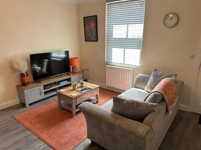 a living room with a couch and a tv at Ground floor 1 bed studio apartment Near station in Downham Market