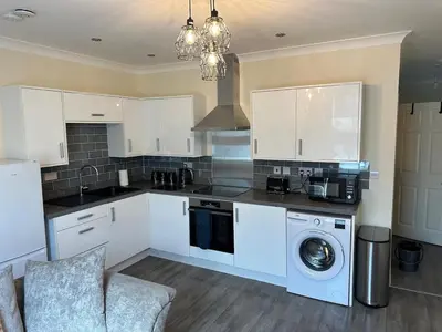 a kitchen with white cabinets and a washing machine at Ground floor 1 bed studio apartment Near station in Downham Market