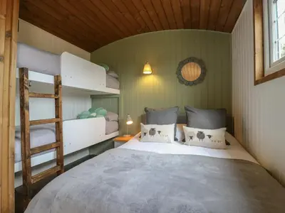 a bedroom with two bunk beds and a ladder at Luxury Shepherd Hut with Private Hot Tub in Swaffham Bulbeck