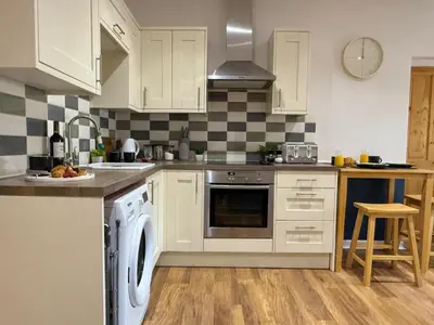 a kitchen with white cabinets and a dishwasher at 2 bed Elegant Flat in Stansted with parking in Stansted Mountfitchet