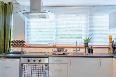 a kitchen with a sink and a large window at Finest Retreats - Hollybush Studio in Knebworth
