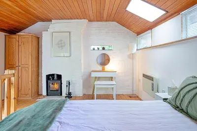 a bedroom with a bed and a fire place at Finest Retreats - Hollybush Studio in Knebworth