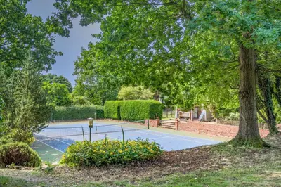 a tennis court in a park with a tree at 2 Bed in Nayland oc-b32342 in Nayland
