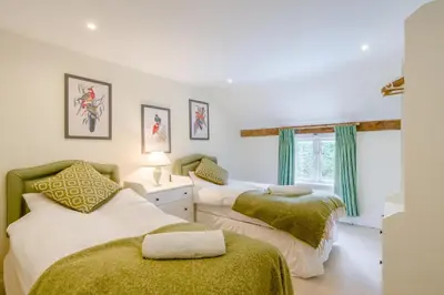 two beds in a bedroom with green and white at 4 Bed in Hartest oc-w32685 in Hartest