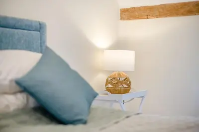 a bed with a blue pillow and a table with a lamp at 4 Bed in Hartest oc-w32685 in Hartest