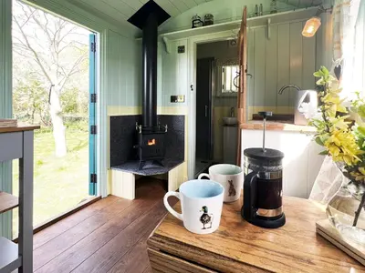 a kitchen with a stove and two cups on a counter at The Hollies Shepherds Hut by The Suffolk Cottage Collection in Sutton