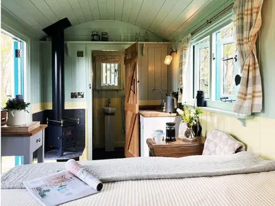 a bedroom with a bed with a book on it at The Hollies Shepherds Hut by The Suffolk Cottage Collection in Sutton
