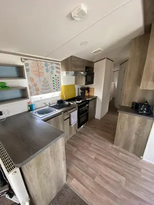 a kitchen with a sink and a stove at Seawick Holiday Park in Saint Osyth