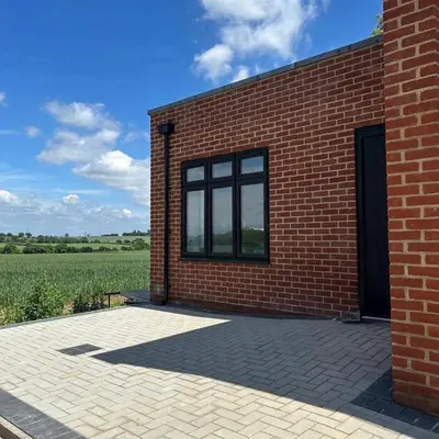 a brick building with a window and a field at Rural Retreats 8 in Southminster