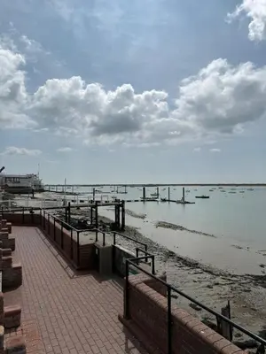 a beach with a pier and the water at Rural Retreats 8 in Southminster