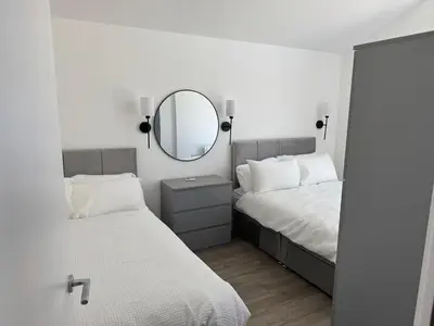 a bedroom with two beds and a mirror at Rural Retreats 8 in Southminster